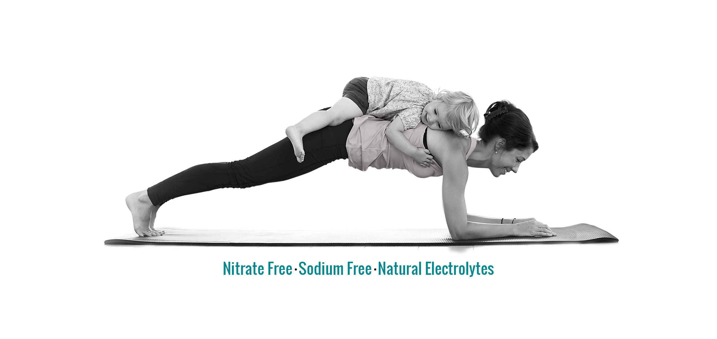 Child resting on his mother’s back, while she does yoga, and the text “Nitrate free, sodium free, natural electrolytes”.